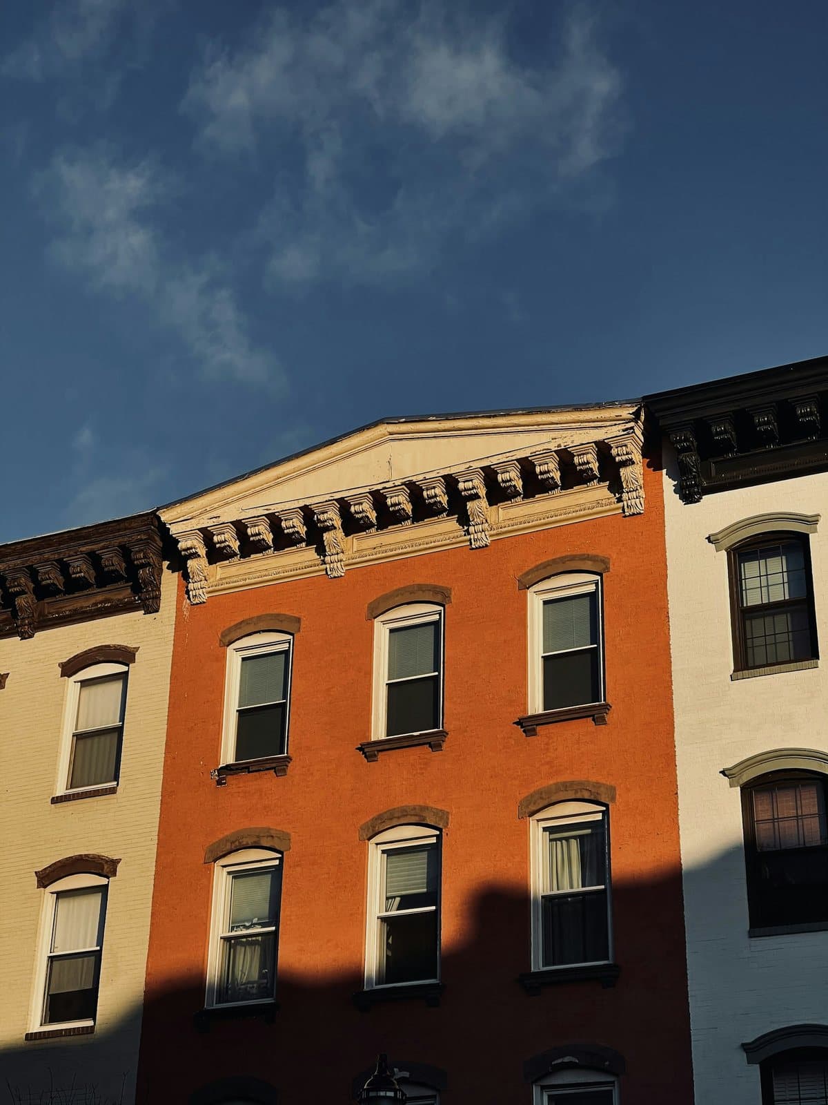 Brownstone rooflines against a blue sky